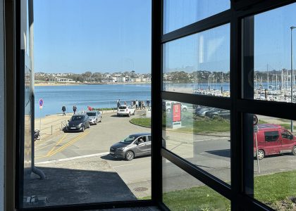 View of seaside town through large window.