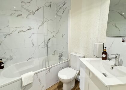 Salle de bain moderne avec baignoire et lavabo.