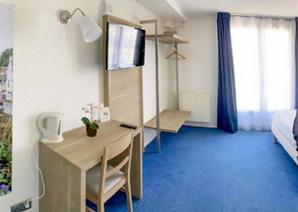 Chambre d'hôtel spacieuse avec lit, bureau, télévision.