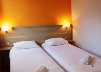 Chambre d'hôtel avec deux lits simples et lampes