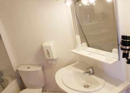 Salle de bain moderne avec miroir et lavabo.