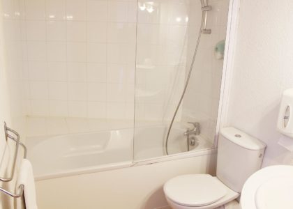 Salle de bain moderne avec baignoire et douche.
